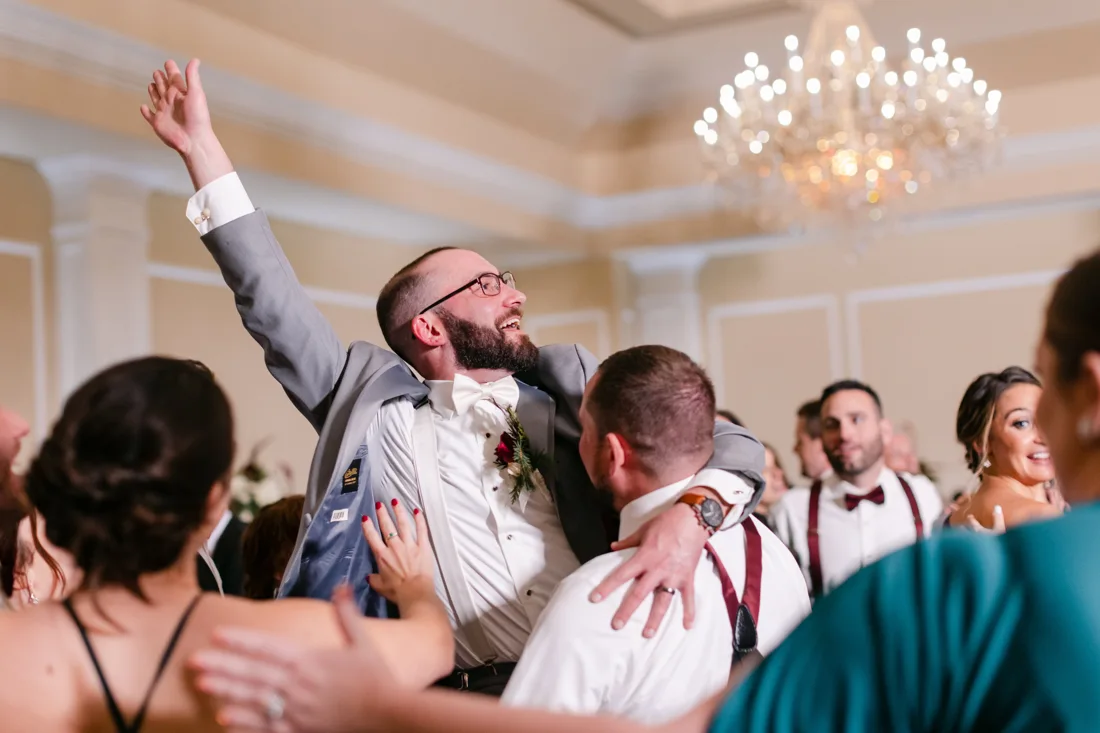 Wedding guests celebrating together with their hands in the air